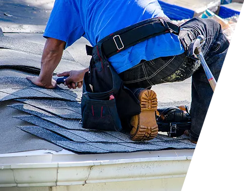 repairing the roof of a home; A worker replaces shingles on the roof of a home