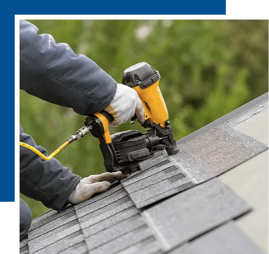 Unrecognizable roofer worker in uniform work wear using air or pneumatic nail gun and installing asphalt or bitumen tile on top of the roof under construction house-min