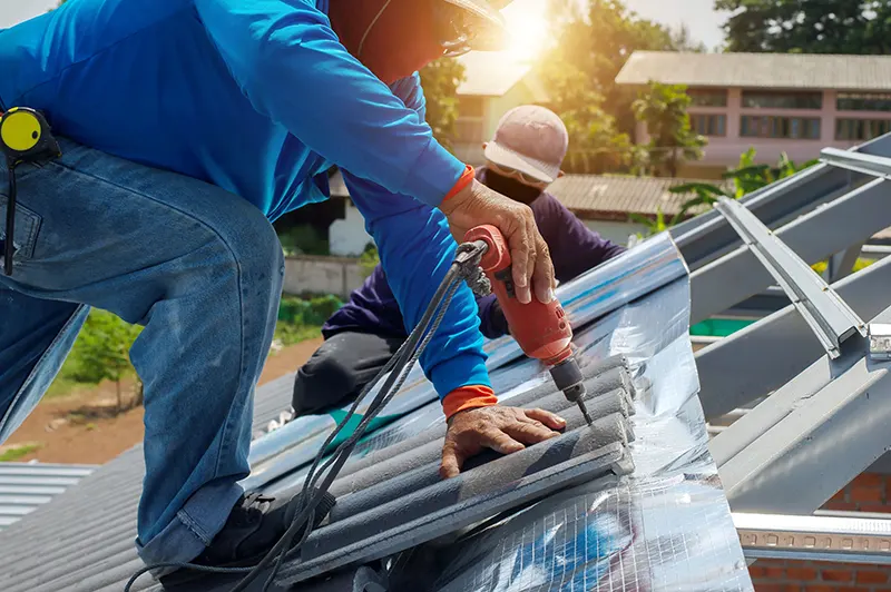 Roof repair, worker replacing gray tiles or shingles on house energy efficiency